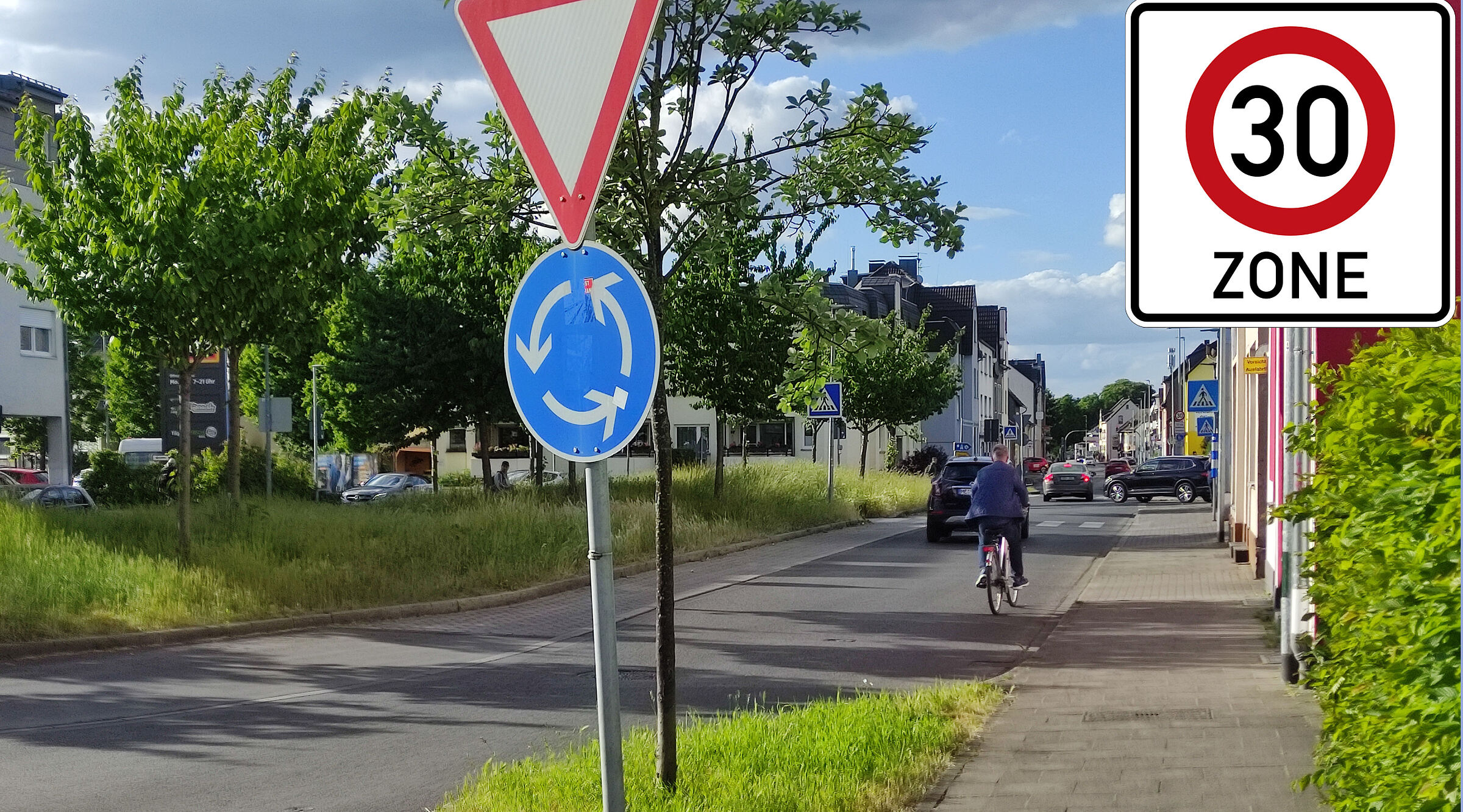 Ein Foto des Kreisverkehrs bei ALDI auf der Gerresheimer Straße. Ein Tempo 30-Zone Zeichen ist überlagert.
