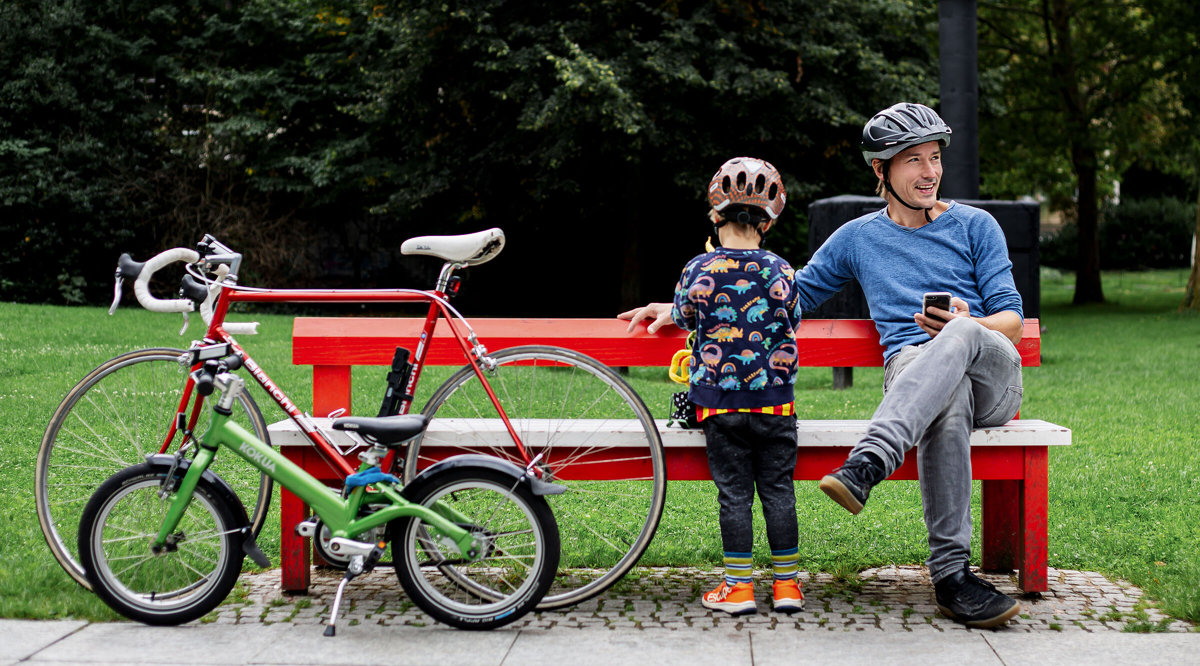 Vater und Kind machen eine Radelpause im Park