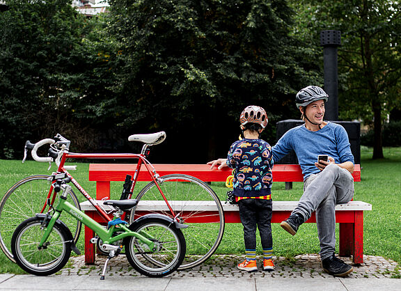 Vater und Kind machen eine Radelpause im Park