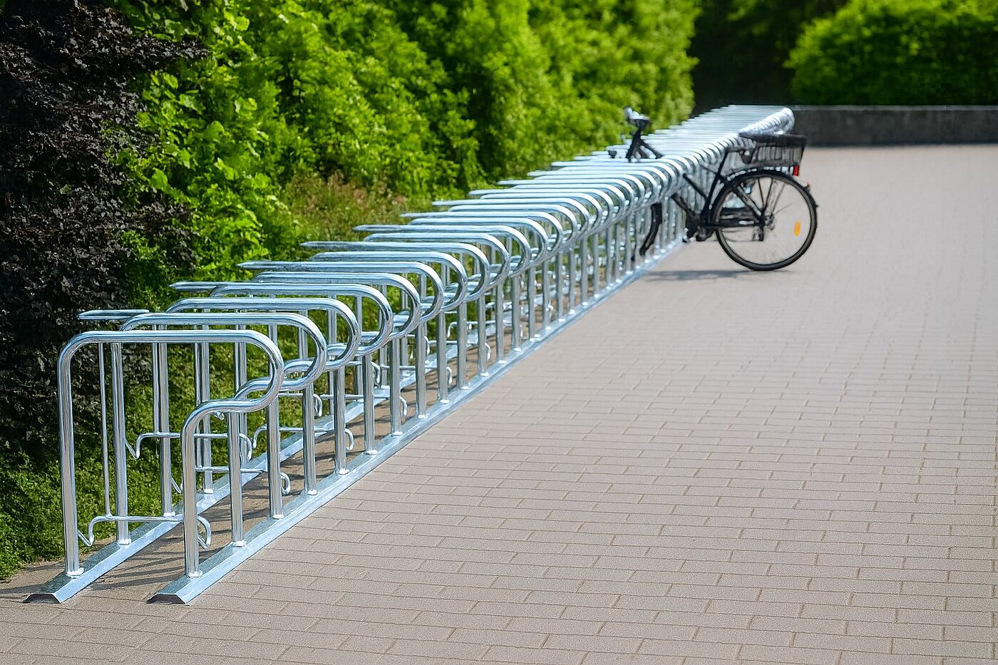 Eine Fahrradabstellanlage aus Stahl auf einem Parkplatz.